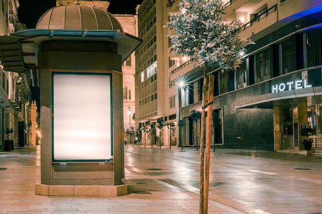 Um outdoor iluminado perto da rua