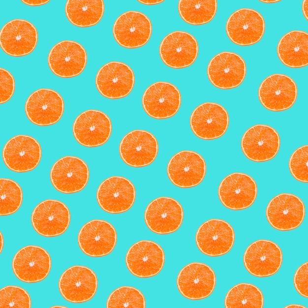 Um padrão de fatias de laranjas no fundo turquesa