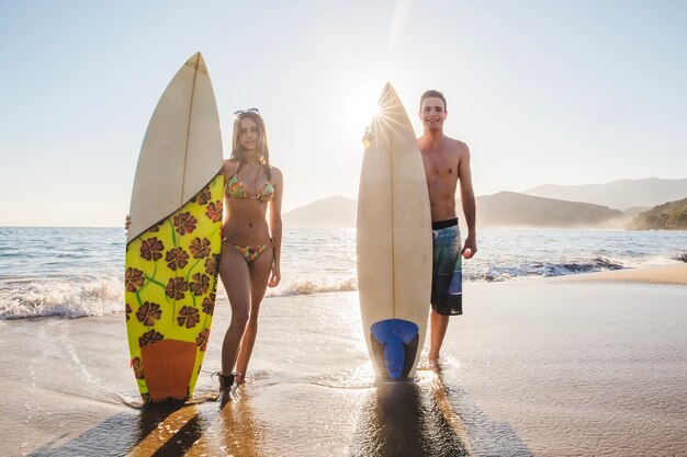 Um par de surfistas com suas pranchas de surfe