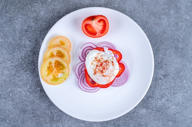 Um prato branco com fatias de tomate e cebola. foto de alta qualidade