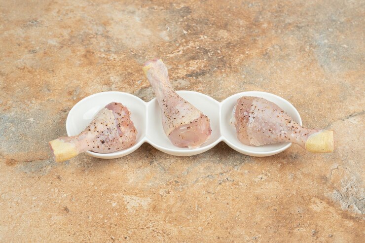 Foto grátis um prato branco de coxas de frango com especiarias