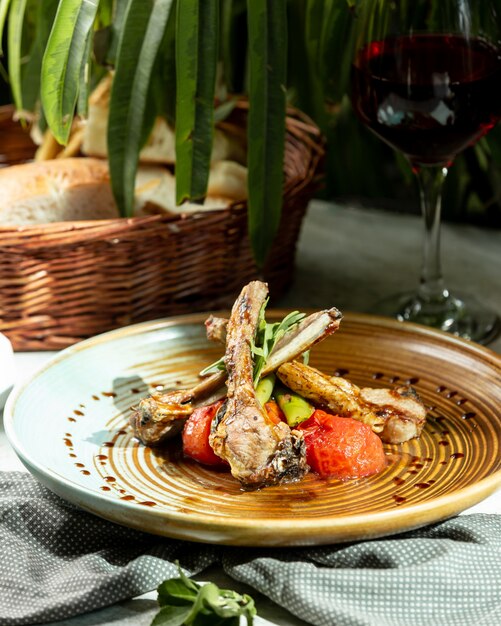 Um prato de costelas de cordeiro, servido com rúcula de tomate defumado e pimenta