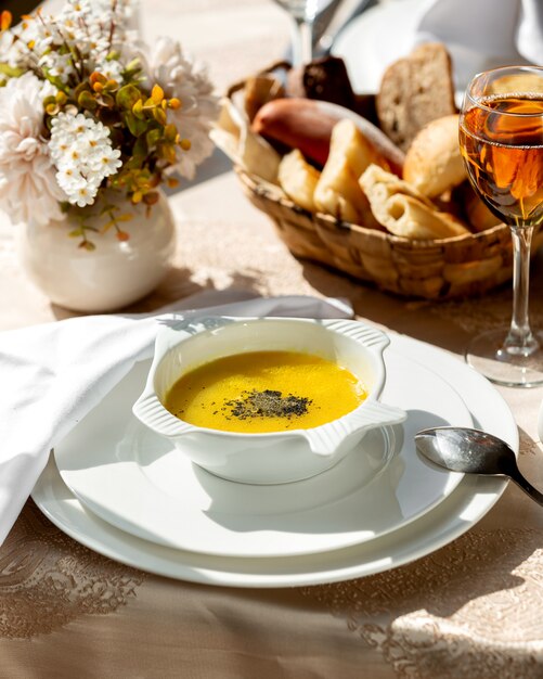 Um prato de sopa de lentilha e uma taça de champanhe