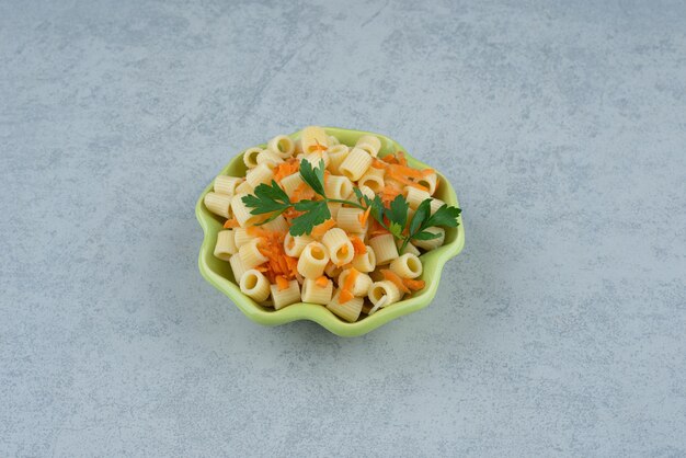 Um prato verde de macarrão com brócolis em fundo branco. Foto de alta qualidade