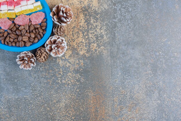 Um quadro azul cheio de diferentes doces de geleia de frutas com pinhas. Foto de alta qualidade