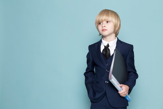 Um rapaz de negócios bonito vista frontal em azul terno clássico segurando pasta preta negócios trabalho moda