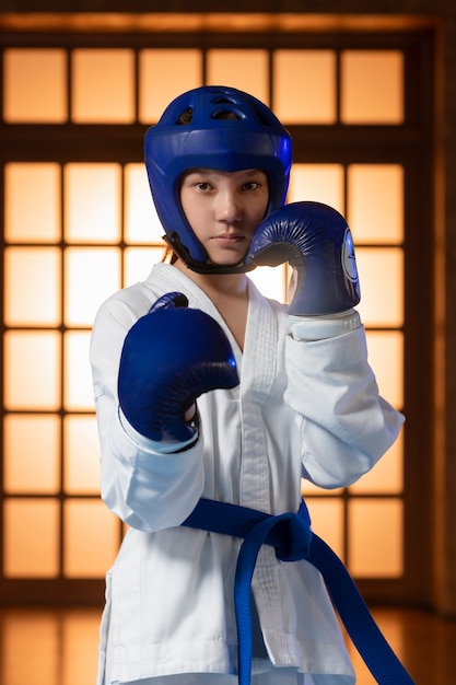 Foto grátis um rapaz de tiro médio a praticar taekwondo.