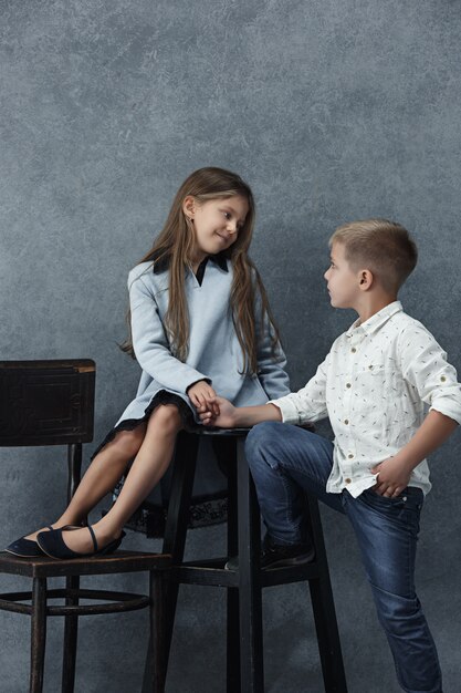 Um retrato de menina e um menino no cinza