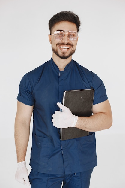 Um retrato de um médico posando contra uma parede branca