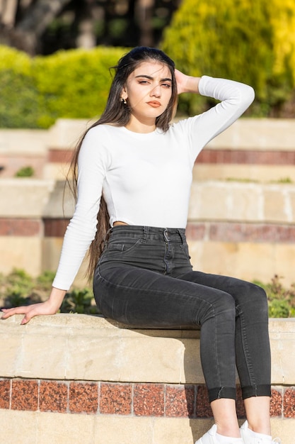 Foto grátis um retrato de uma jovem confiante sentada na rua foto de alta qualidade