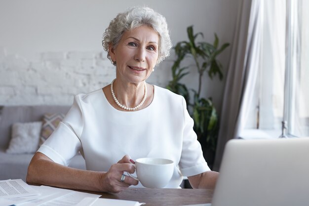 Um retrato de uma mulher de negócios sênior trabalhando em ambientes fechados