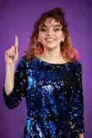 Foto grátis um retrato vertical de uma jovem de cabelos encaracolados levantou o dedo e rindo foto de alta qualidade