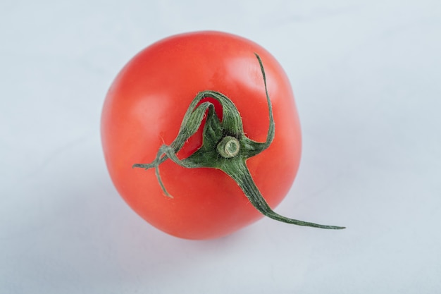 Um saboroso tomate fresco em uma superfície branca.