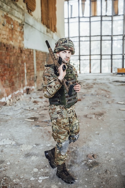 Um soldado uniformizado usa um grande rifle nas mãos