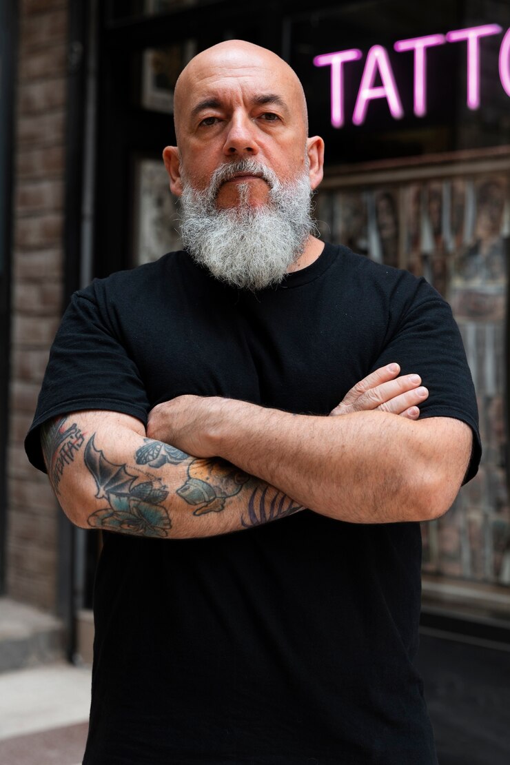 Foto grátis um tatuador experiente em frente ao seu estúdio.