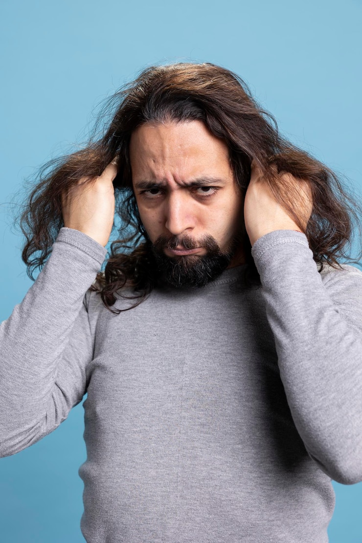 Foto grátis um tipo do oriente médio a agir desesperadamente e a arrancar o cabelo para a câmara.
