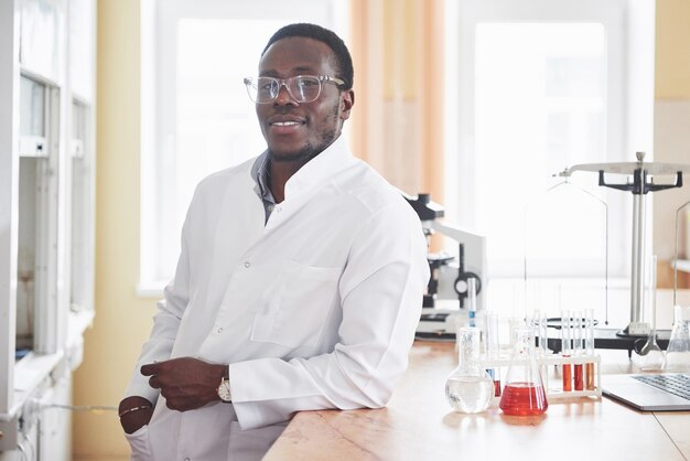 Um trabalhador afro-americano trabalha em um laboratório conduzindo experimentos.