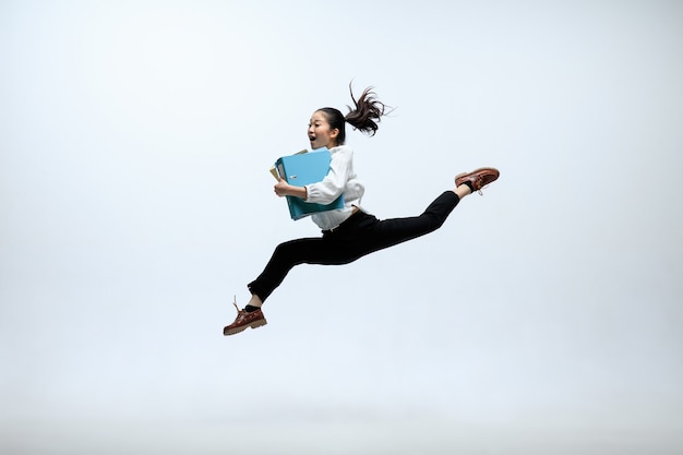 Foto grátis um último segundo para atingir o alvo. mulher feliz trabalhando no escritório, pulando e dançando com roupas casuais ou terno isolado no fundo branco do estúdio. negócio, start-up, conceito de espaço aberto de trabalho.