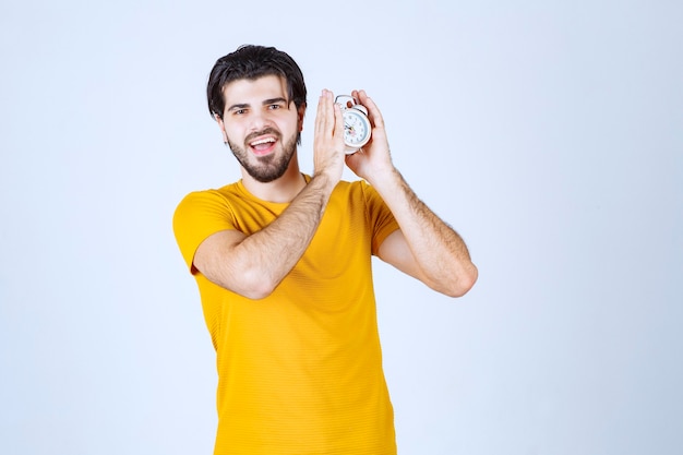 Foto grátis um vendedor segurando e promovendo o despertador.