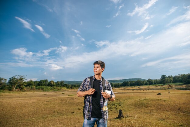 Um viajante do sexo masculino com uma mochila carregando um mapa e de pé no Prado.