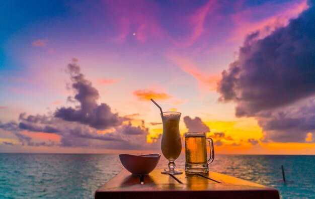 Um vidro da cerveja com a ilha tropical bonita de Maldives.