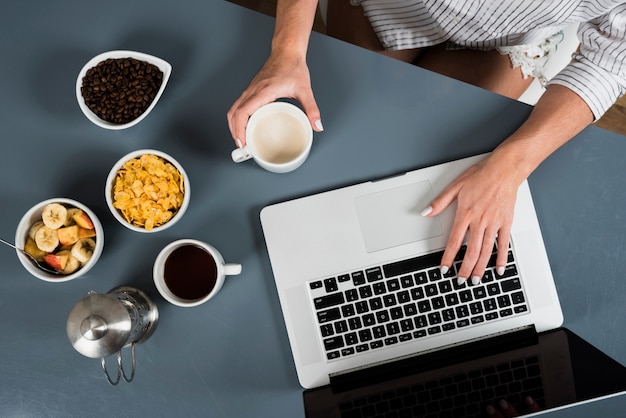 Um, visão aérea, de, mulher, com, saudável, pequeno almoço, usando computador portátil