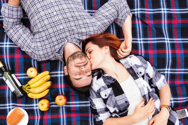 Foto grátis um, visão aérea, de, mulher jovem, beijando, dela, namorado, mentindo, ligado, cobertor