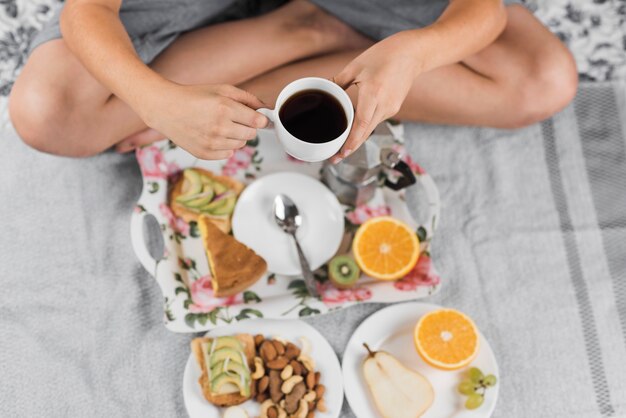 Um, visão aérea, de, um, menino sentando, ligado, cama, xícara café segurando