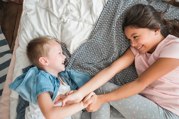 Um, visão geral, de, sorrindo, irmão irmã, tirando sarro, cama