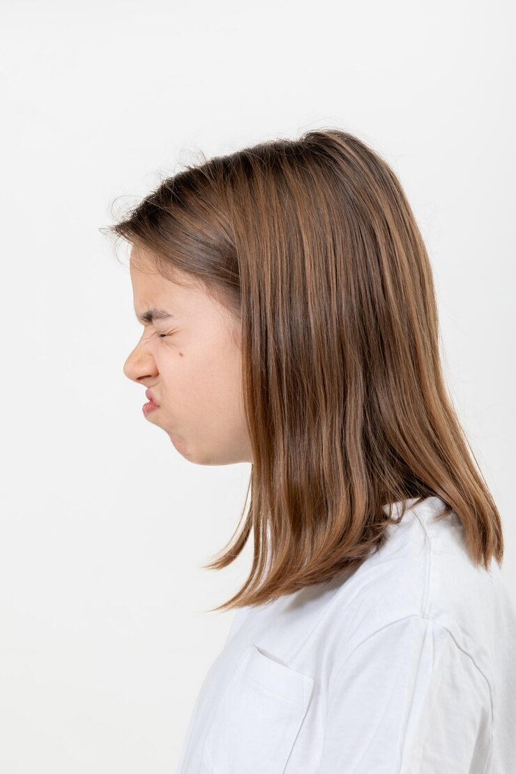 Foto grátis uma adolescente faz caretas de desagrado em um fundo branco isolado