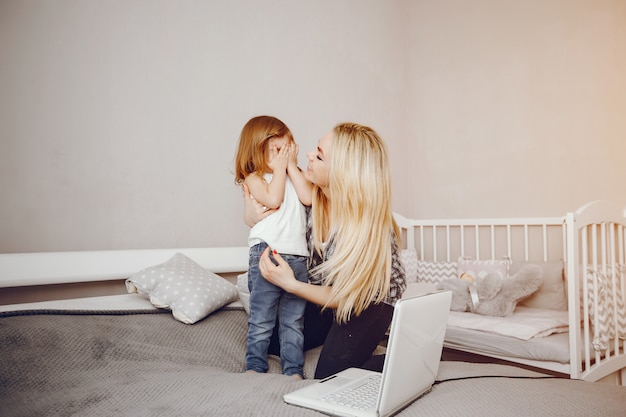 Uma bela jovem mãe com sua filha jogando em casa