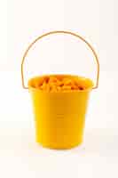 Foto grátis uma cesta de vista frontal com massas secas massas italianas de laranja dentro de cesta amarela no branco