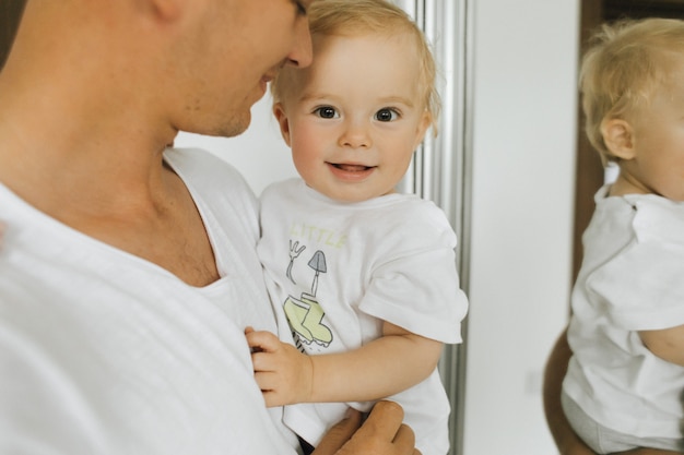 Uma criança pequena se alegra nas mãos de seu pai