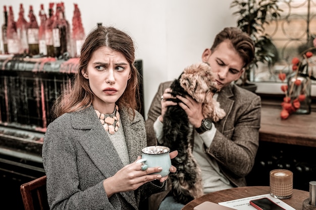 Uma distribuição de atenção. mulher fica chateada porque seu parceiro está prestando atenção apenas em seu cachorro