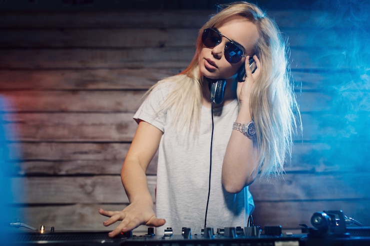 Foto grátis uma dj bonita a divertir-se a tocar música numa festa de clube.