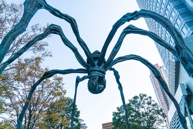 Foto grátis uma escultura de aranha de louise bourgeois, situada na base do edifício da torre mori em colinas de roppongi