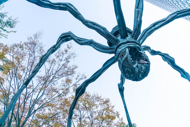 Foto grátis uma escultura de aranha de louise bourgeois, situada na base do edifício da torre mori em colinas de roppongi