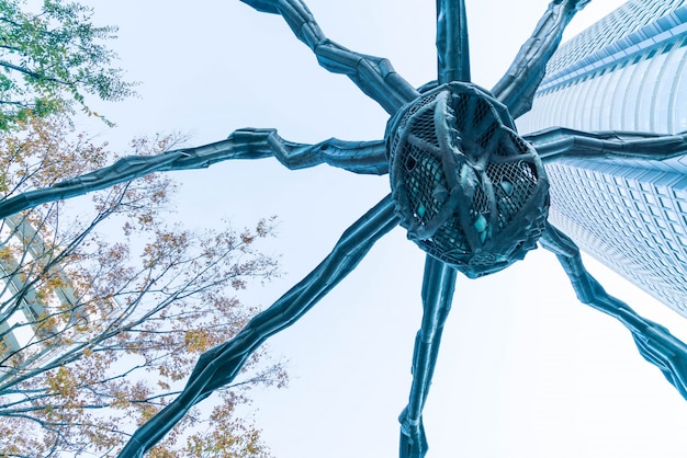 Foto grátis uma escultura de aranha de louise bourgeois, situada na base do edifício da torre mori em colinas de roppongi