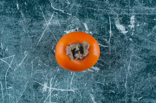 Uma exibição de caqui maduro, na mesa de mármore. Foto gratuita