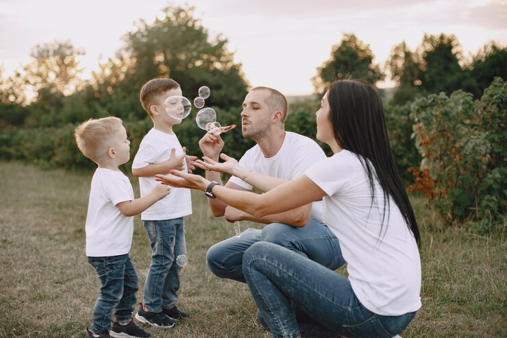Foto grátis uma família bonita a brincar num campo de verão.