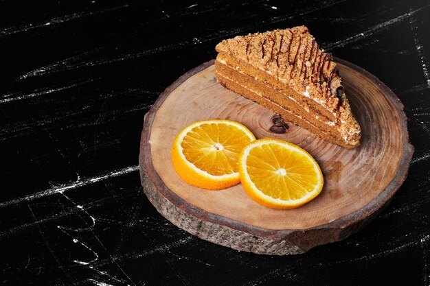 Uma fatia de bolo de mel com rodelas de laranja.
