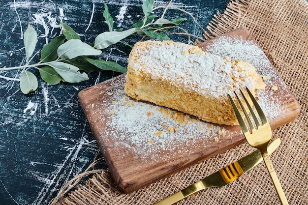 Uma fatia de bolo de mel em uma placa de madeira.