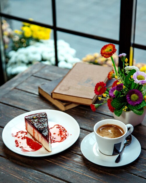 Uma fatia de cheesecake de framboesa servida com café expresso