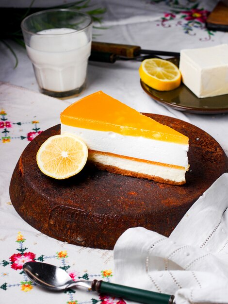 Uma fatia de cheesecake de limão, guarnecida com uma fatia de limão