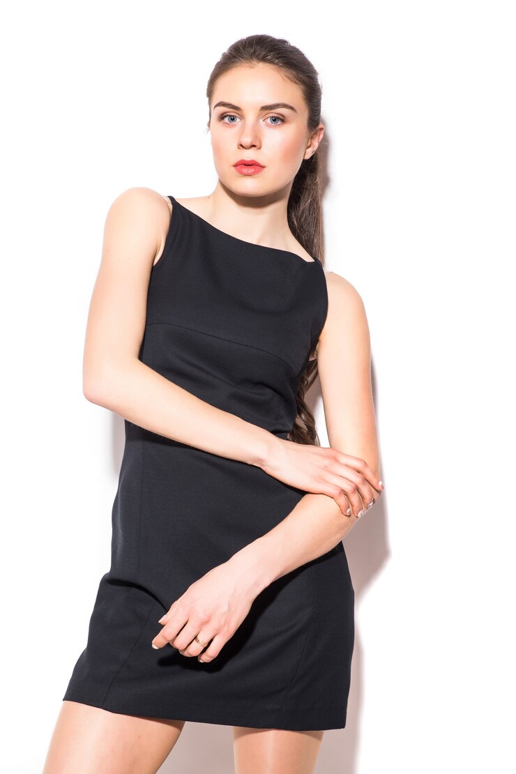 Foto grátis uma foto de uma jovem mulher bonita em um vestido preto posando sobre fundo branco