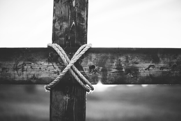 Uma foto em tons de cinza de uma cruz de madeira feita à mão