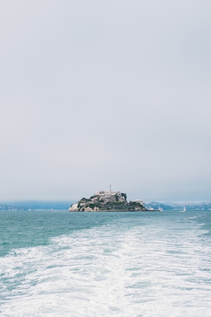 Uma foto vertical de uma ilha no meio do mar