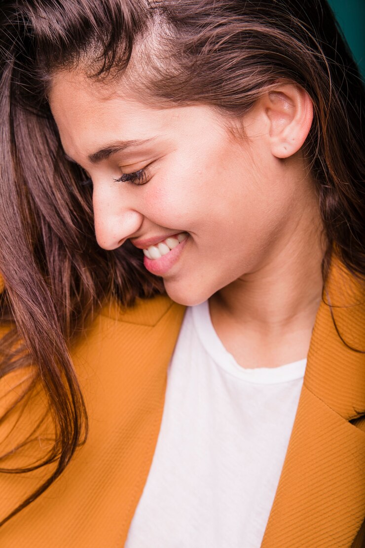 Foto grátis uma garota morena sorridente posando com um casaco