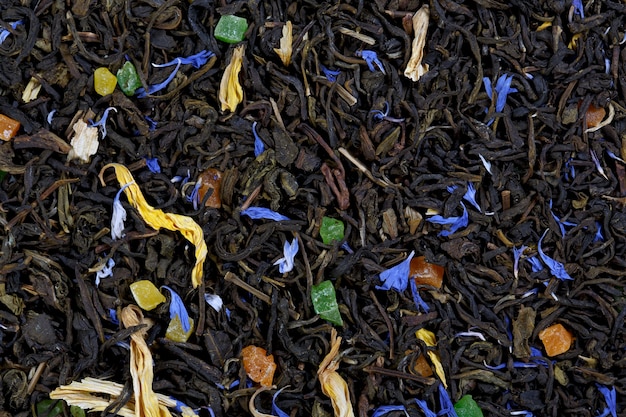 Uma grande folha de chá verde, pétalas de centáurea, pétalas de girassol, frutas cristalizadas coloridas.
