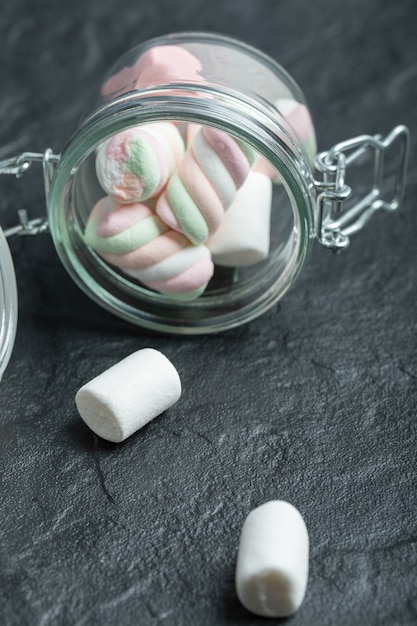 Foto grátis uma jarra de vidro cheia de marshmallows em uma superfície escura.